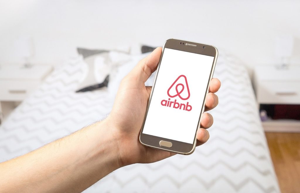 airbnb image on smartphone in bedroom of a rental property