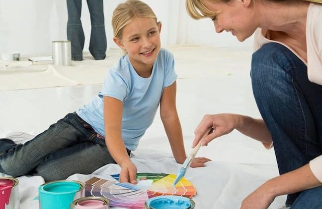 mother and daughter painting with multiple colors, white background